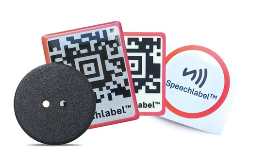 Zestaw Starter Pack przedstawiający czarny guzik, dwie wypukłe etykiety z kodami QR oraz okrągłą etykietę NFC z logo Speechlabel